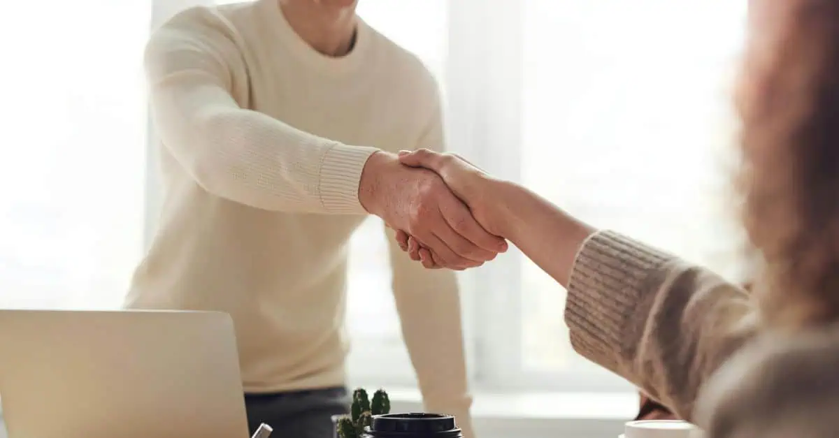 Eomployees shaking hands illustrating new employee onboarding