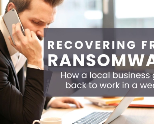 Recovering from Ransomare: How a local business got back to work in a week. Man at desk on phone with cconcerned look on his face