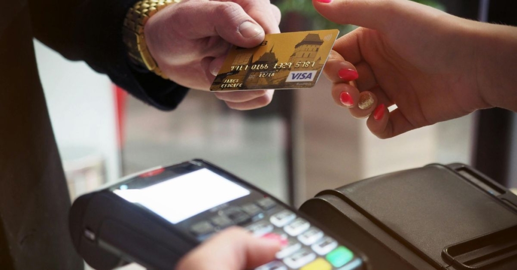 Hand holding credit card at payment station