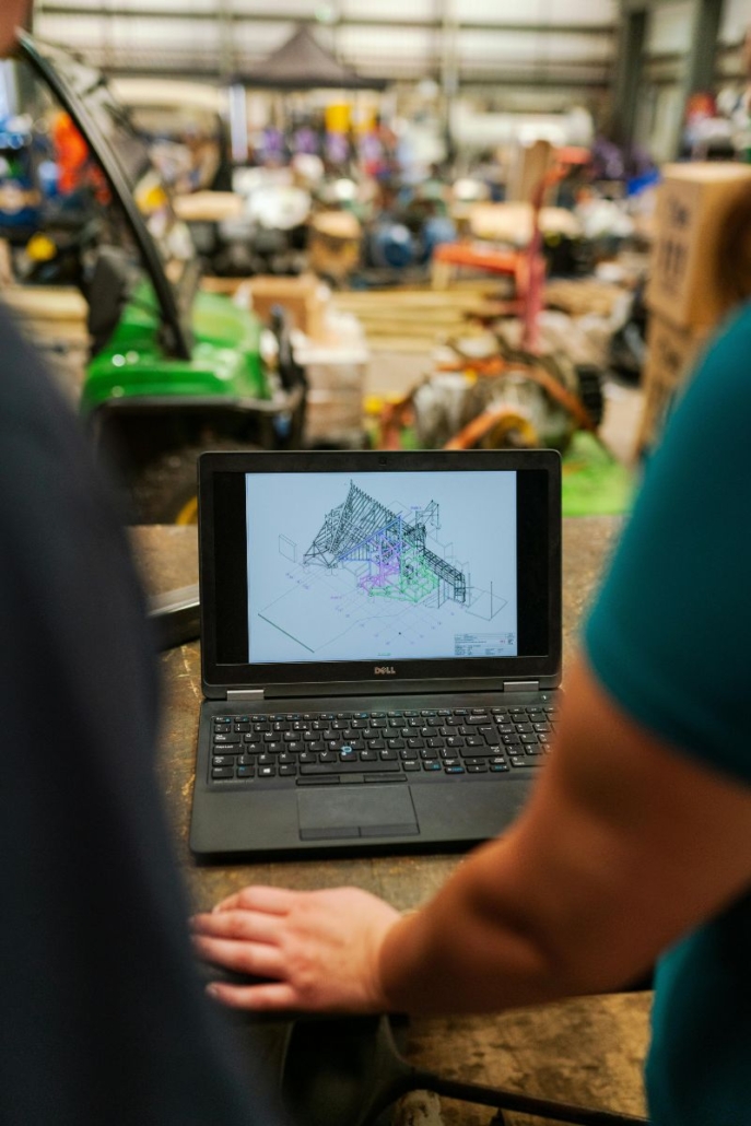 two workers at laptop looking at a design