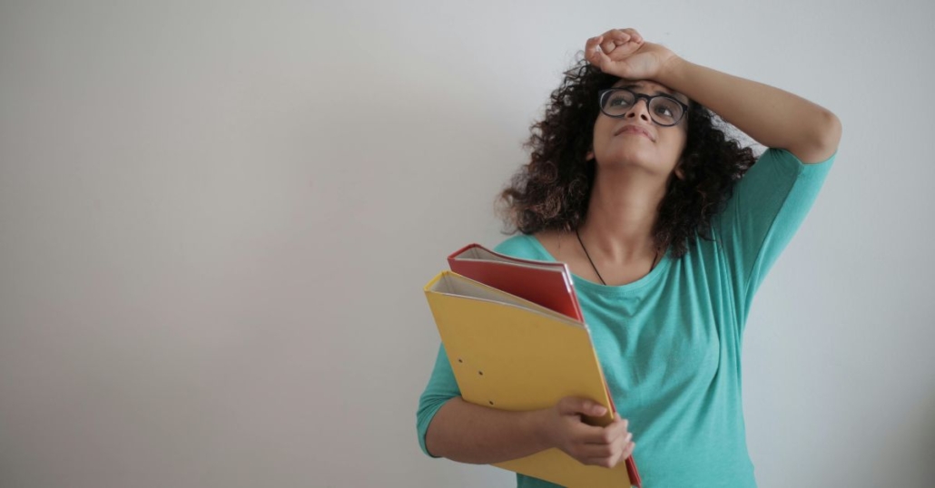 woman holding binders of paperwork